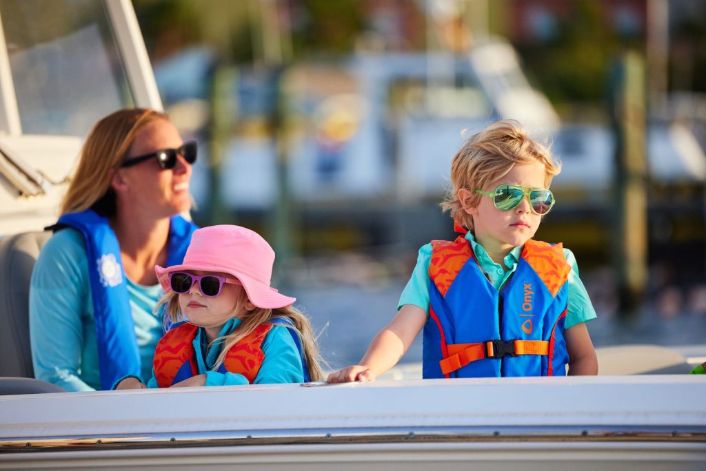 A woman and two kids in lifejackets