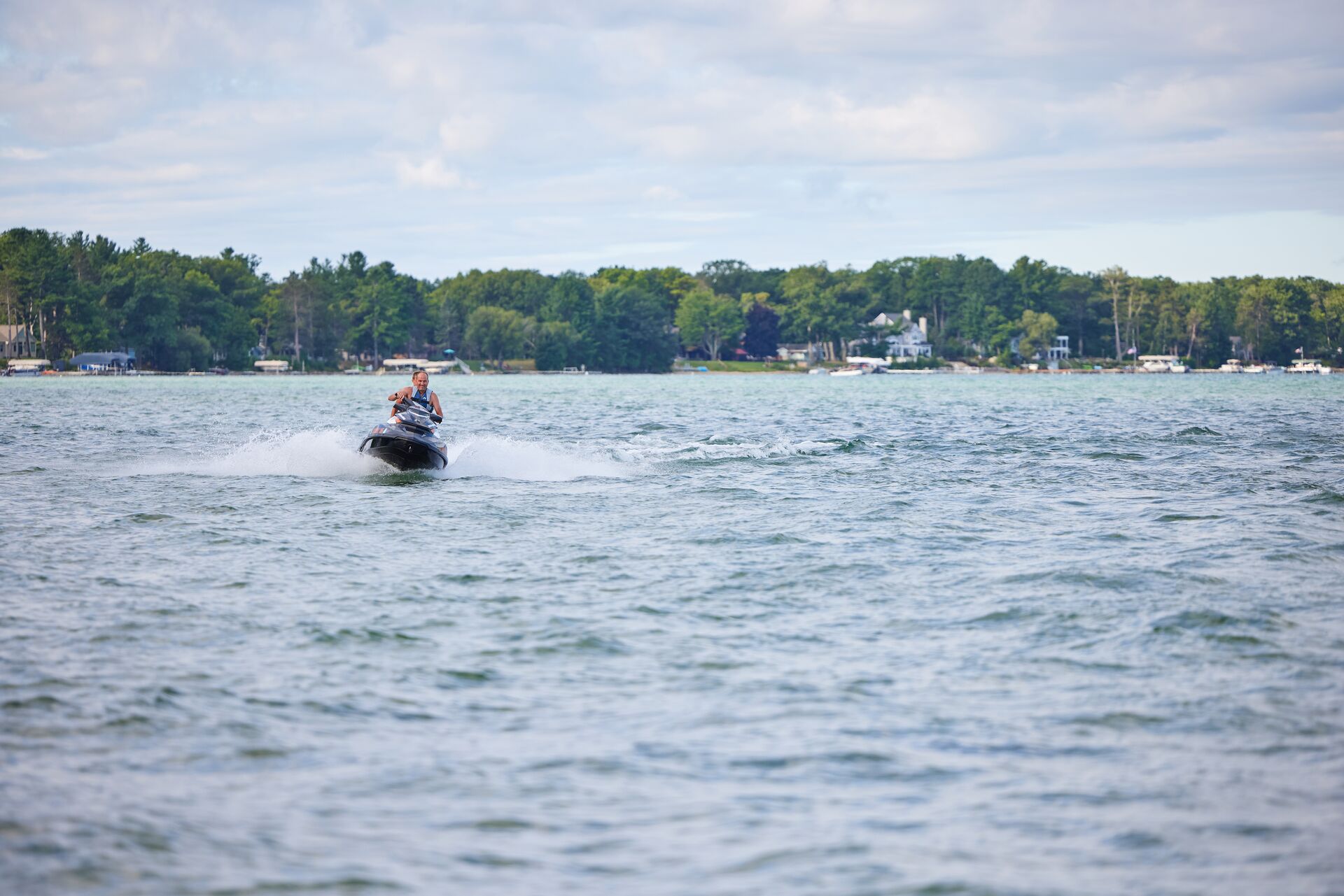 Riders on a personal watercraft (PWC) on a lake. 