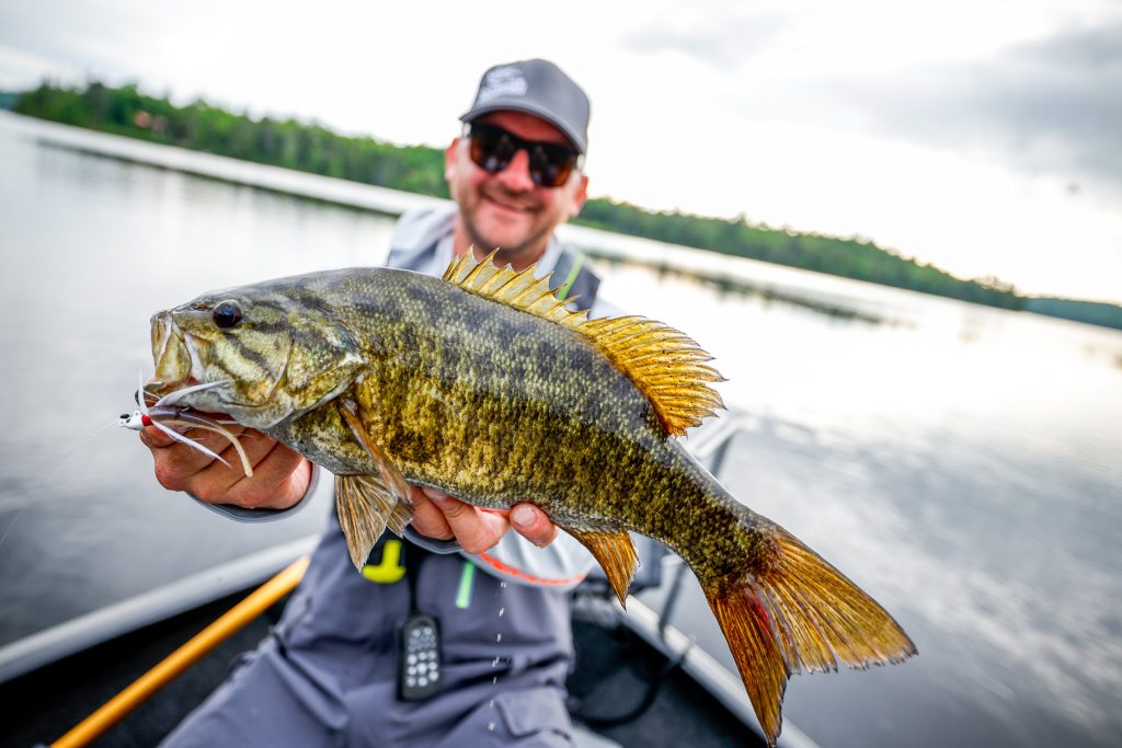 An anglers holds up a fish, have fun after buying a fishing boat concept. 