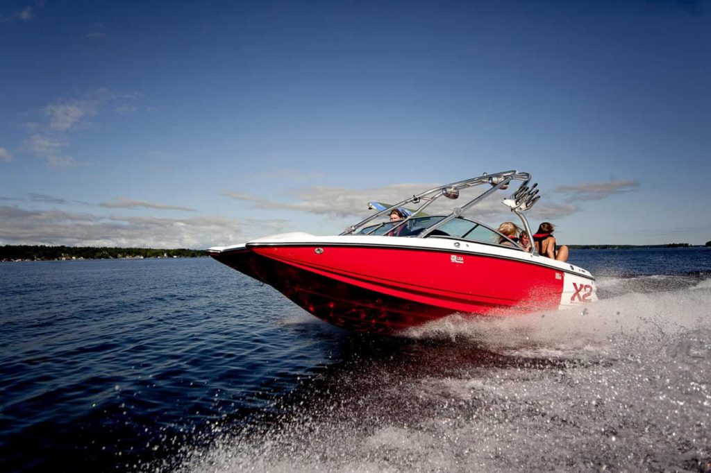 A jet boat on the water with people on board. 