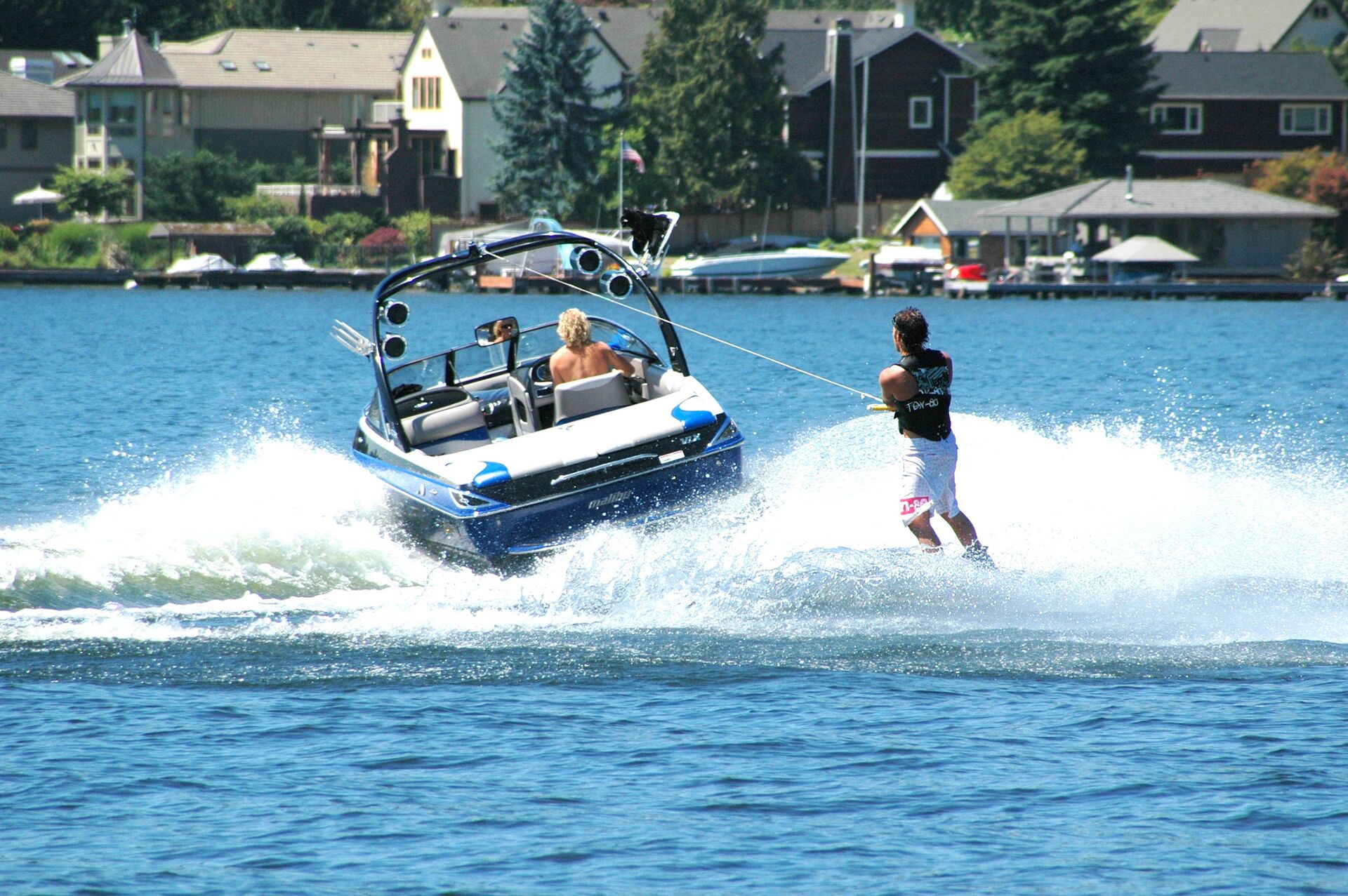 A guy waterskis behind a fast boat, enjoy New York's waterways concept. 