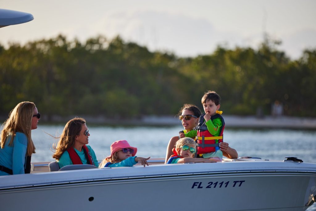 Women and children wearing life jackets on a boat, boating during coronavirus concept. 