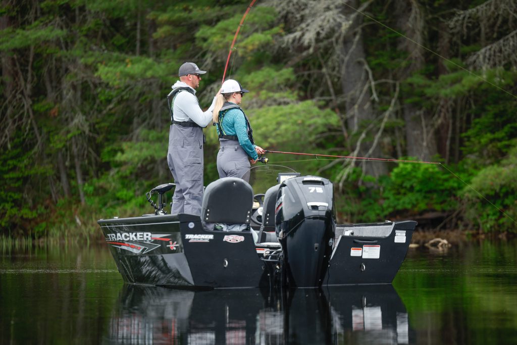 Two people fishing on a boat. 