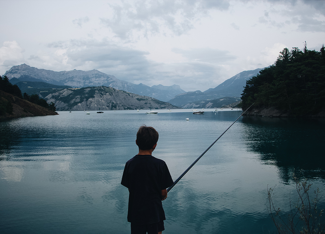 A boy fishing at a lake, boat and fish in New York concept. 