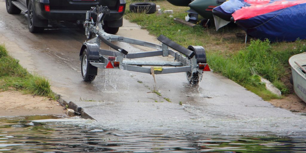 An empty boat trailer on a boat ramp, launching for spring boating concept. 