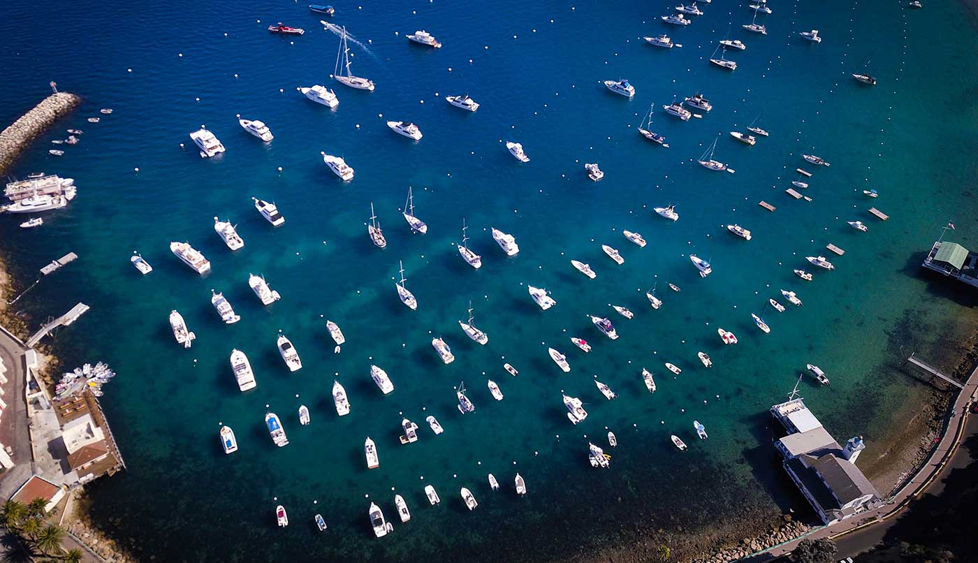 Overhead view of many boats docked near shore, learn South Dakota boating laws concept. 