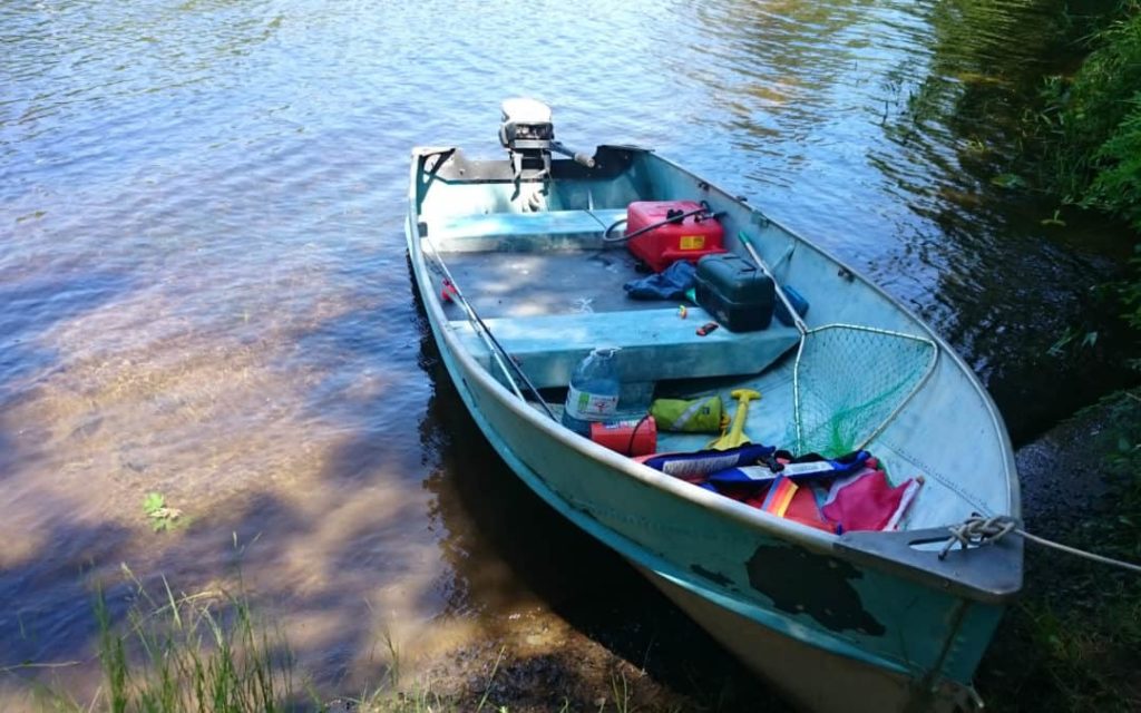 A tin boat tied to shore after repairs, boating DIY project concept. 