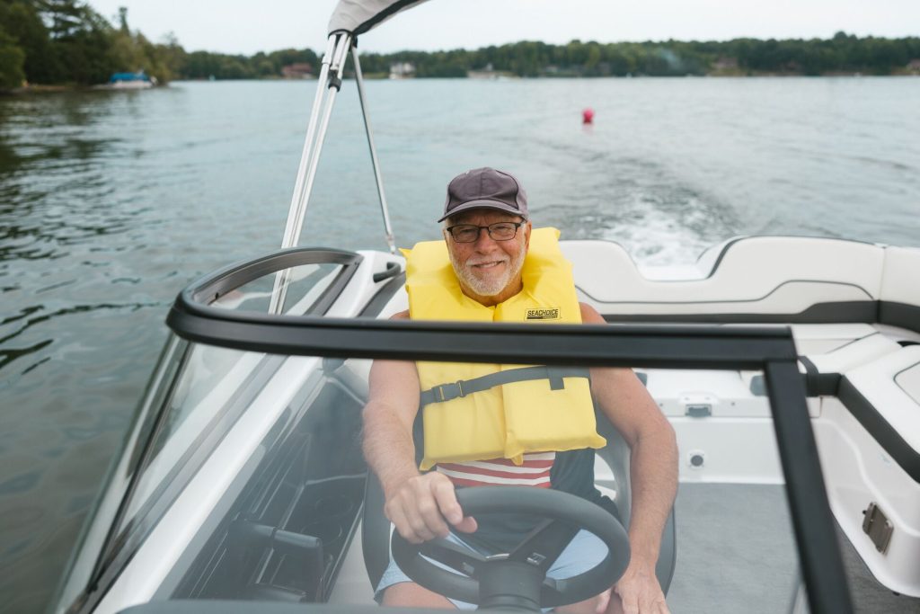 A man wears a yellow life jacket while driving a boat, Florida boat registration concept. 