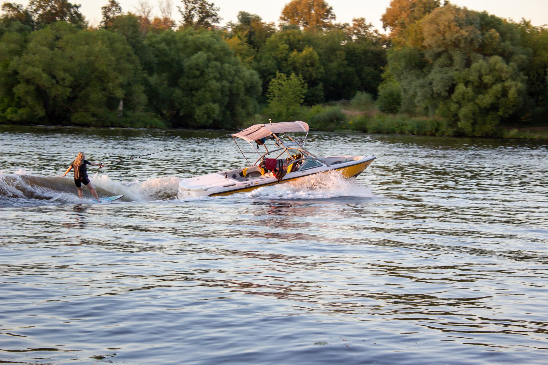 A boat pulls a person on a wakeboard behind the boat, follow Delaware boating laws concept. 