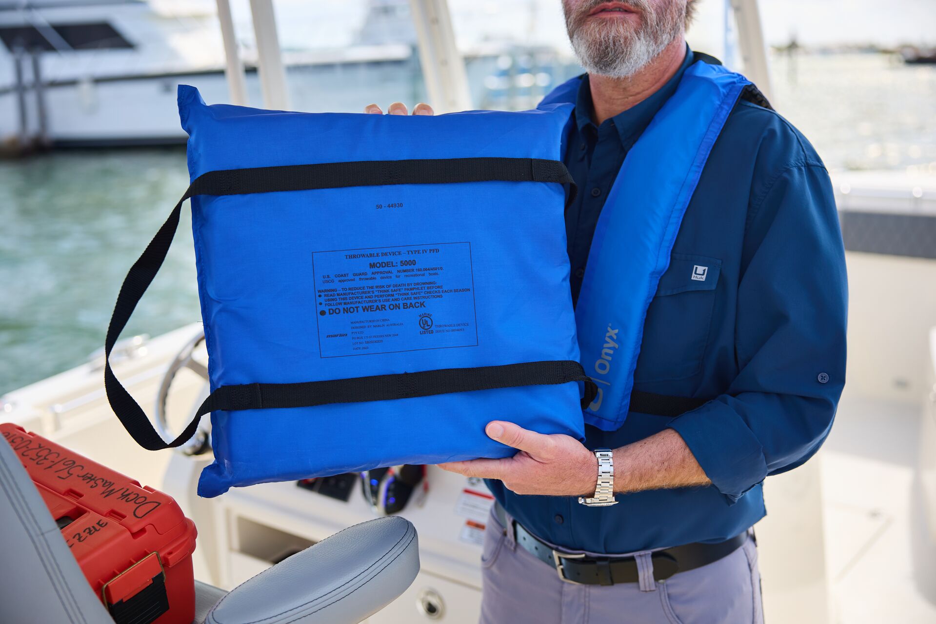 A boater holds up a throwable personal flotation device, boat safety equipment concept. 