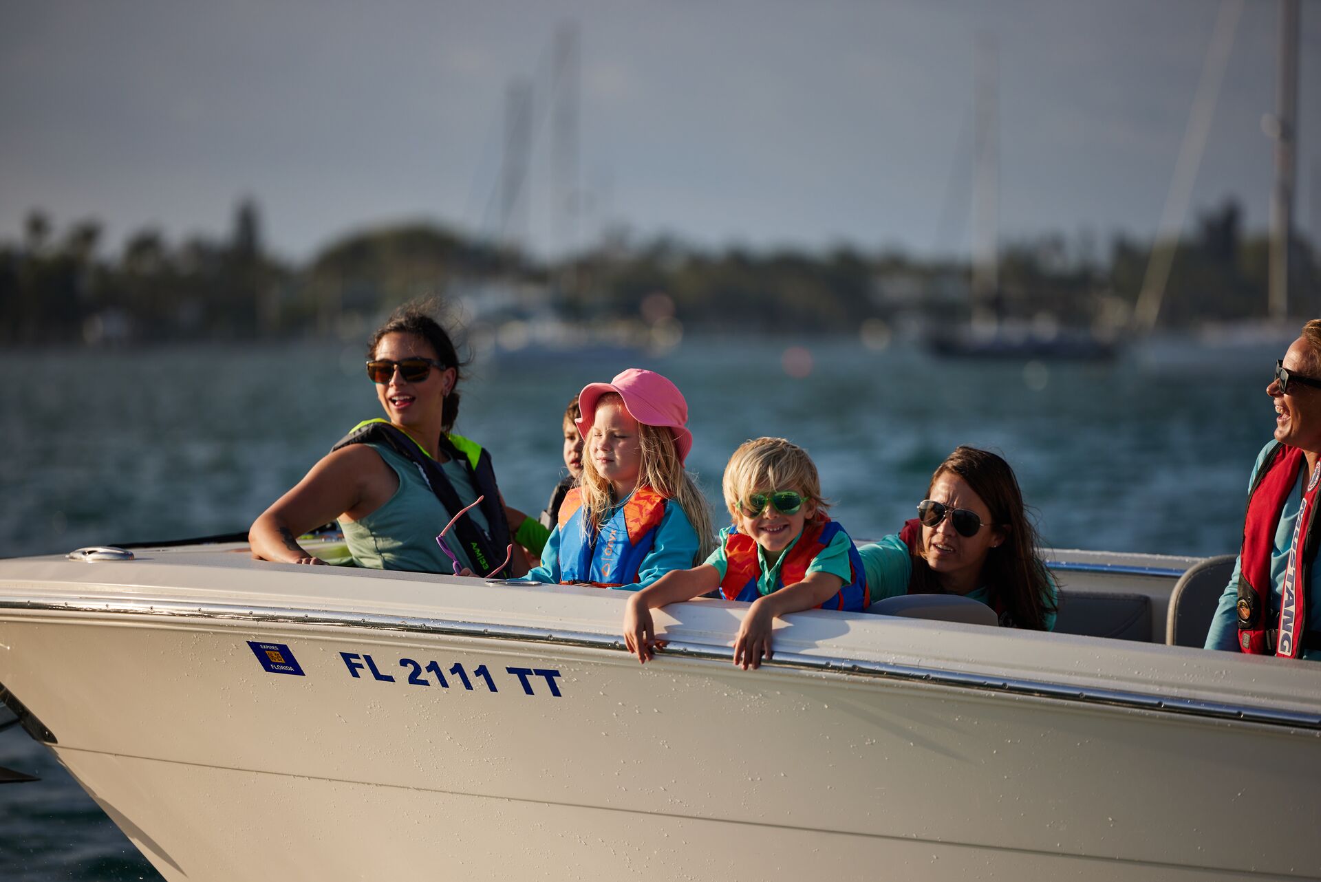 Kids and women wearing life jackets on a boat, boating in Hawaii concept. 