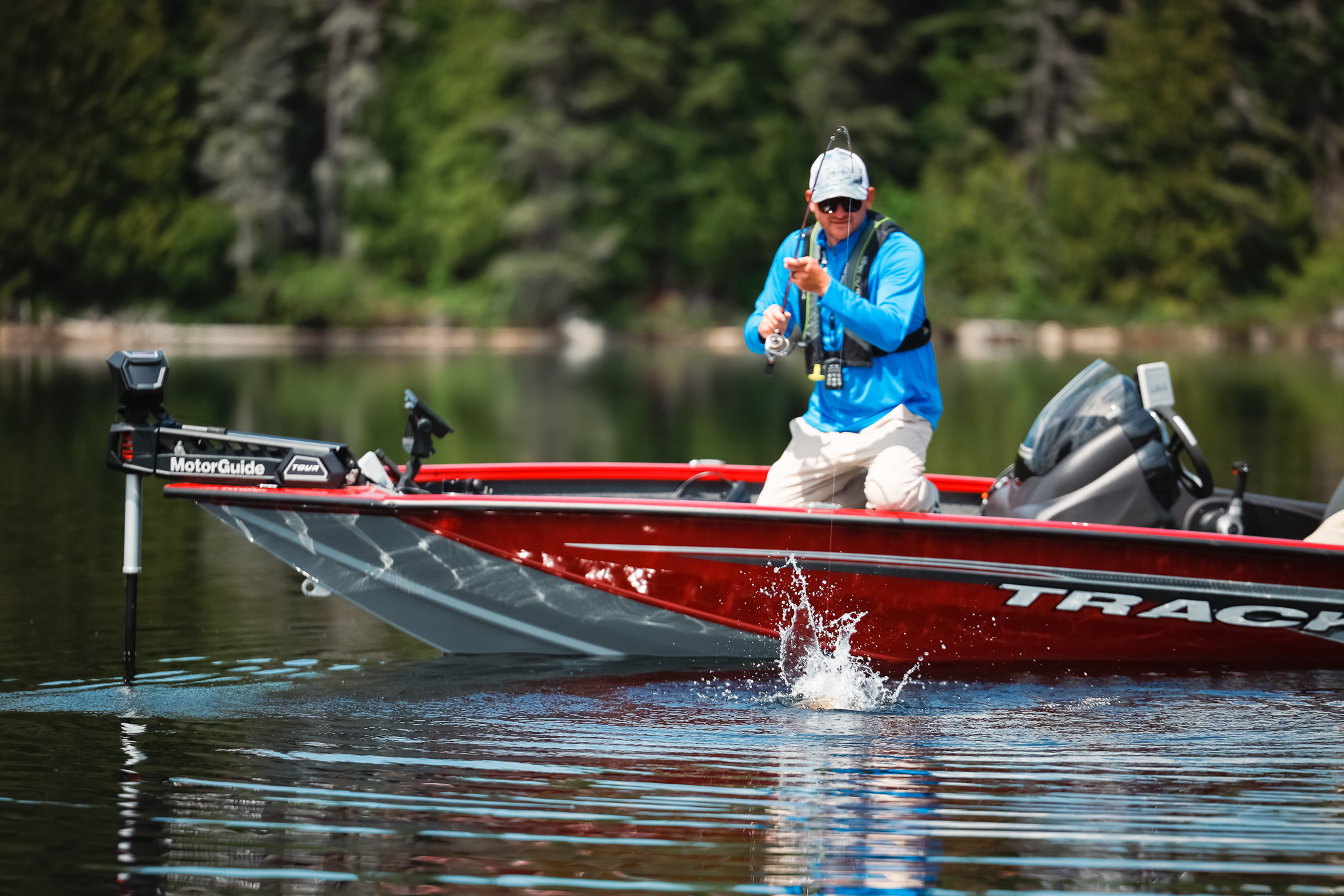 An angler wearing a life jacket reels in a fish while on a boat, learn Delaware boating laws concept.