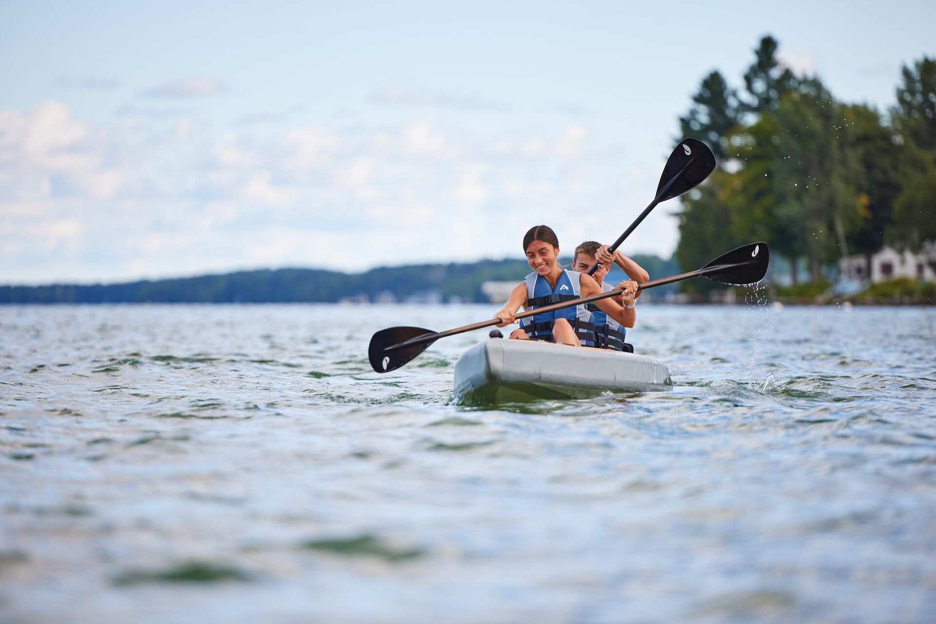 Two people paddling a canoe on a lake.