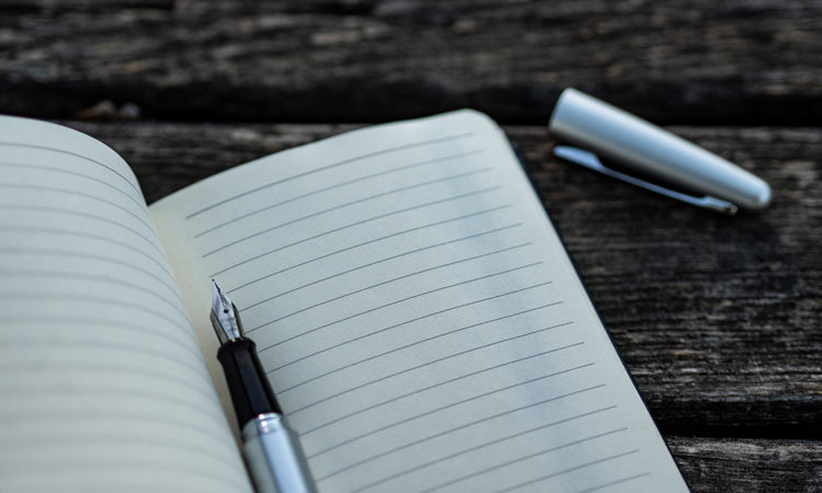A pen on a blank notebook page, boat maintenance checklist concept.