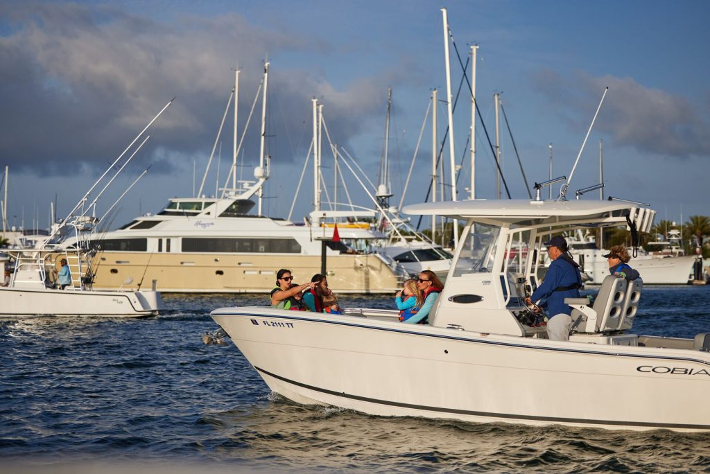 A boat driving by other boats at a marina, marinas in New York concept.