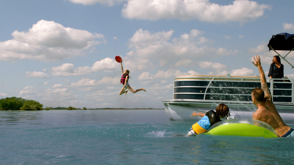 People swimming near a boat, get your New York boater safety certificate concept.