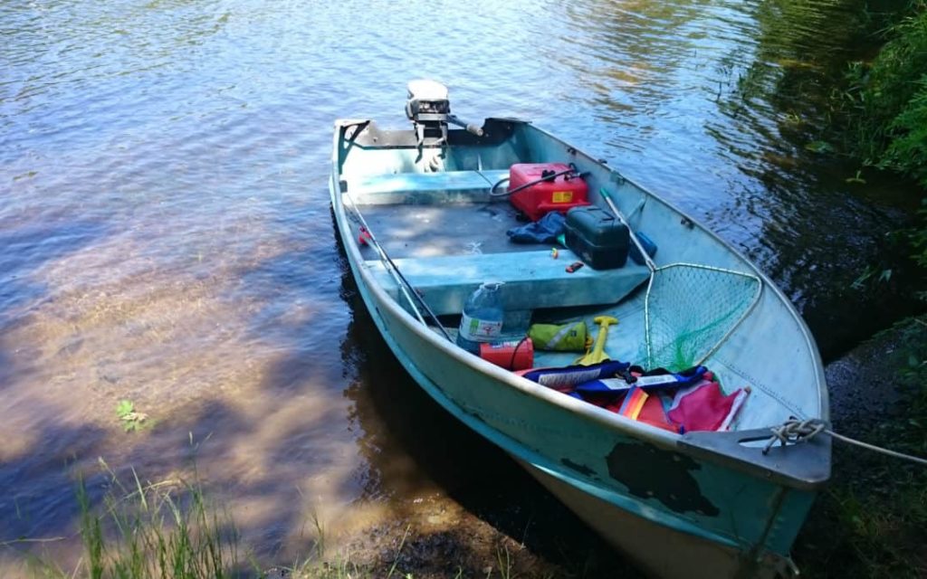 A tin boat tied to shore after repairs, boating DIY project concept.