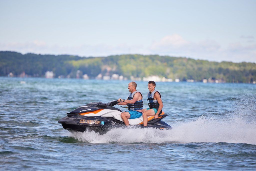 Two people on a personal watercraft on the water.