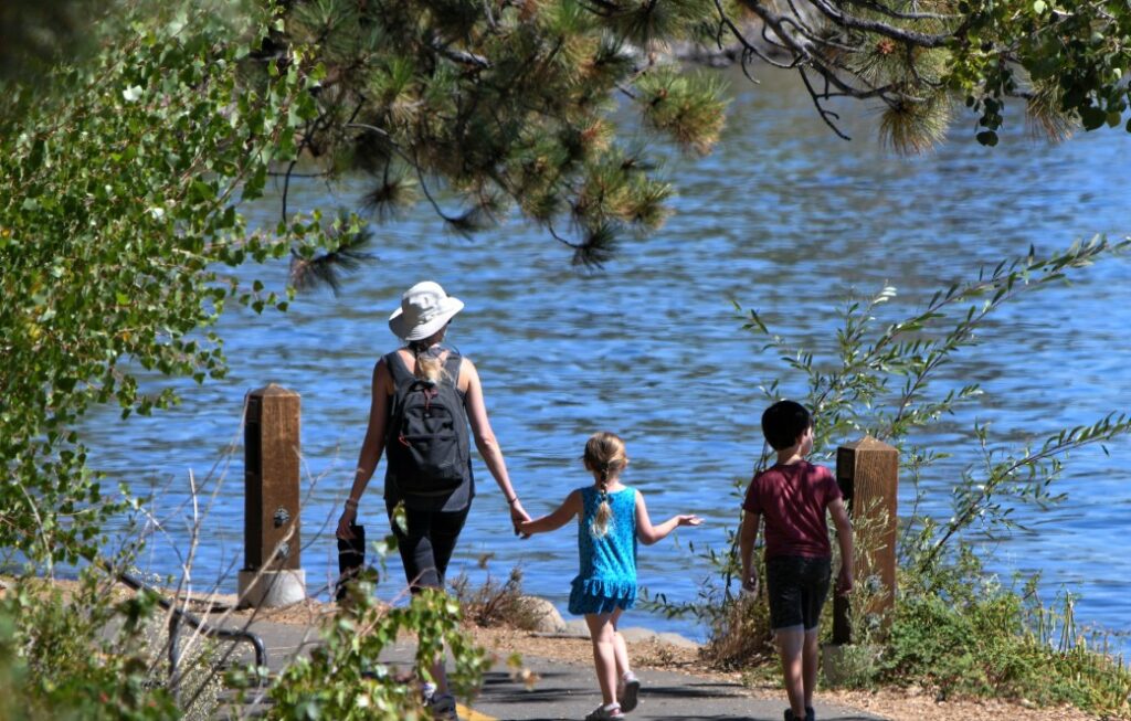 A woman and children walking on a dock, understanding boating access rules concept.