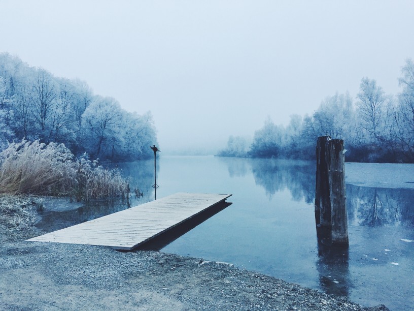A dock on a cold lake during winter, how to winterize your boat concept.