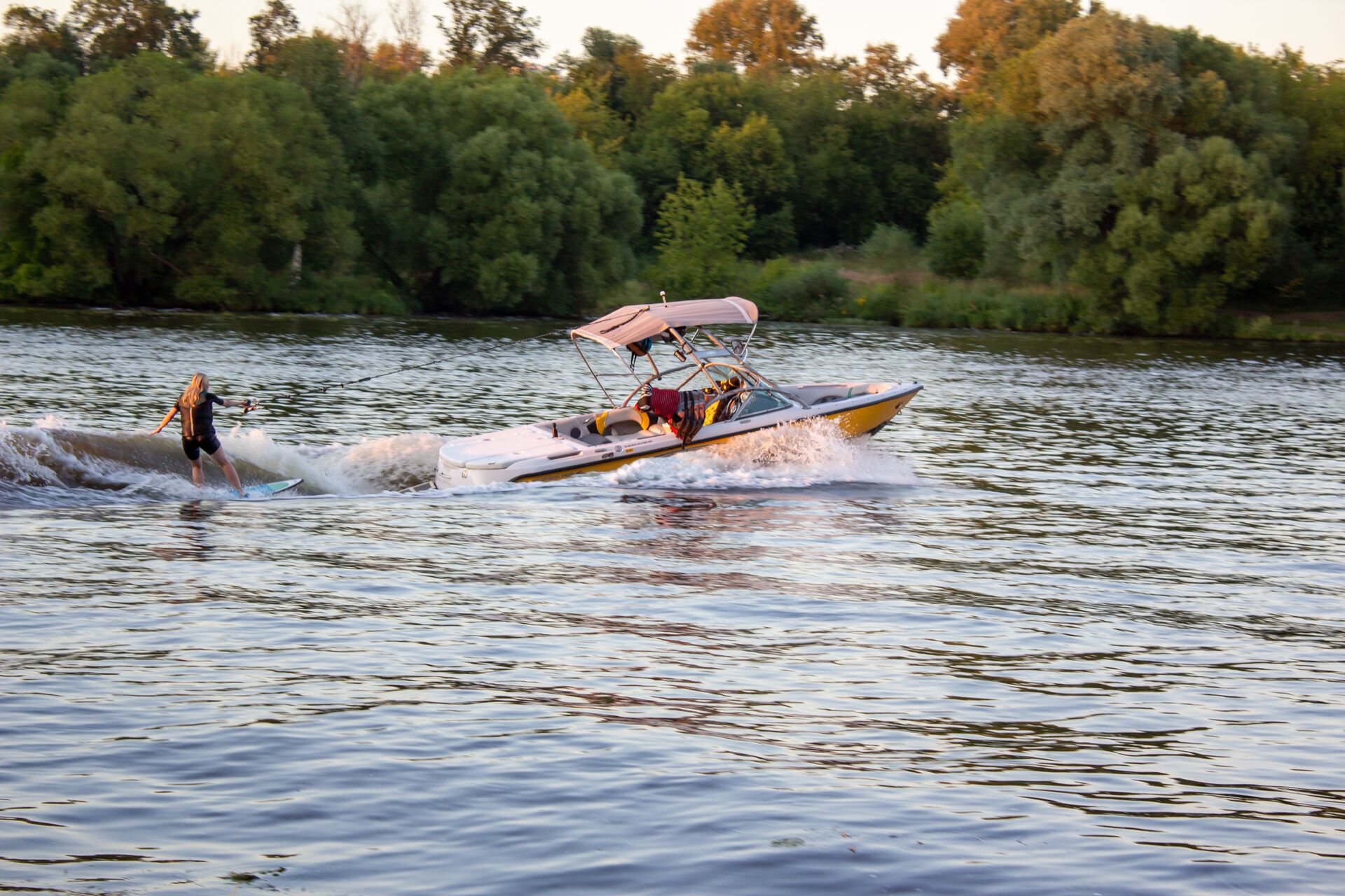A boat pulls a person on a wakeboard behind the boat, follow Delaware boating laws concept.