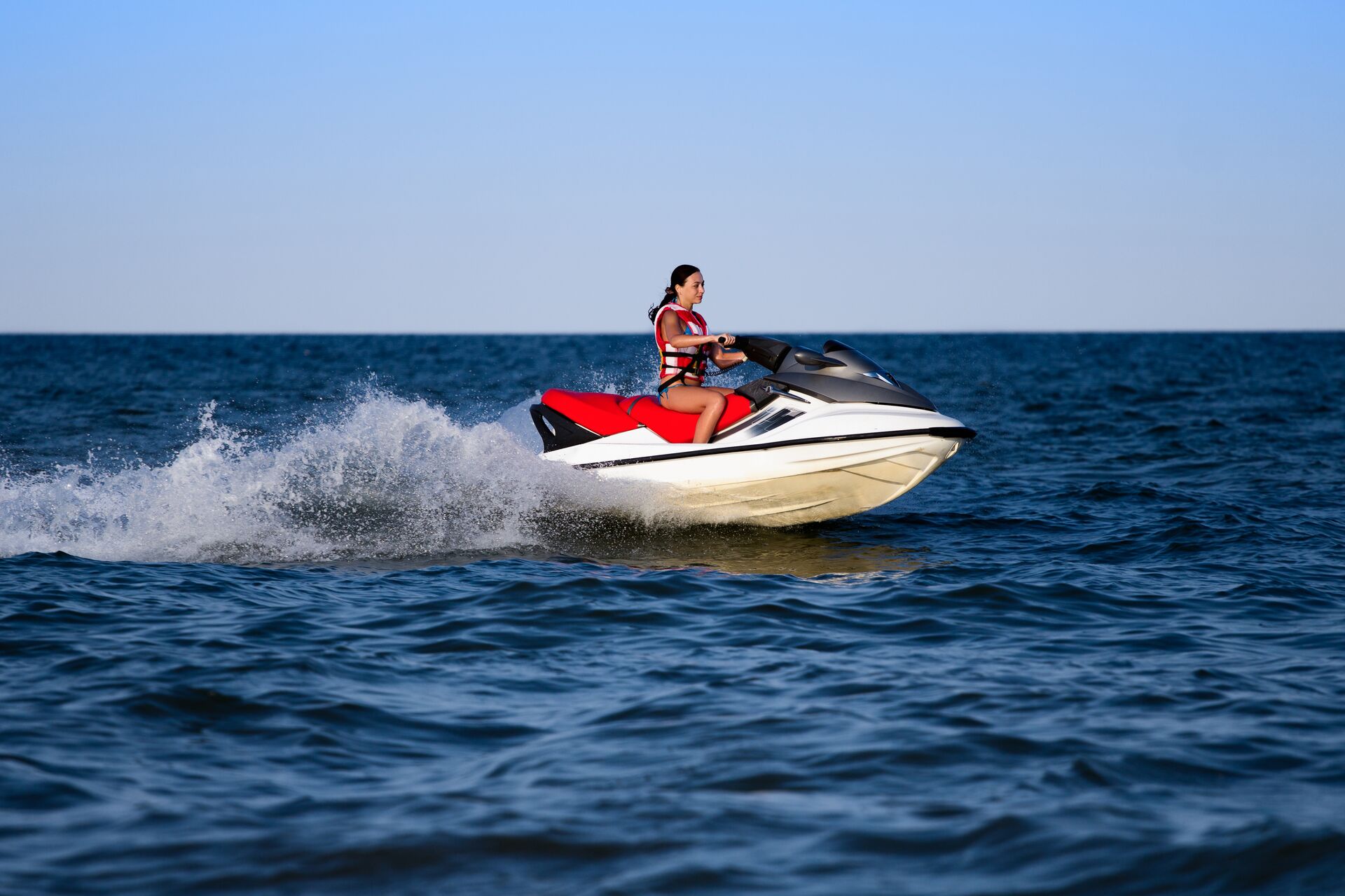A girl riding a PWC, following North Dakota boating laws concept.