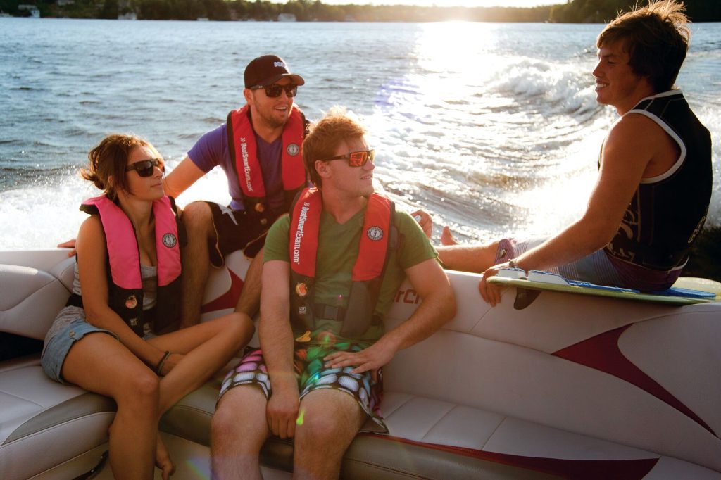 Four young people sit on a boat, avoid alcohol and boating concept. 